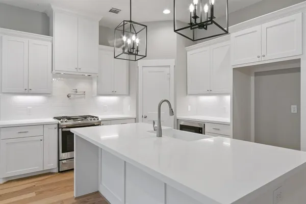a kitchen with stainless steel appliances a sink a stove and cabinets