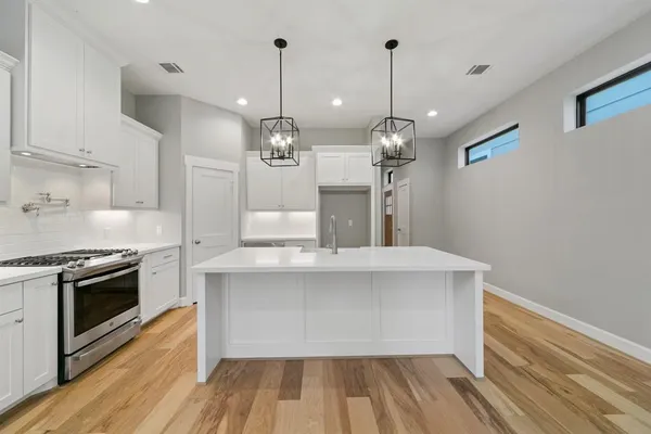 a large kitchen with sink and stainless steel appliances