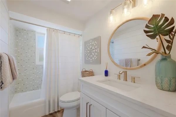 a bathroom with a sink mirror toilet and bathtub