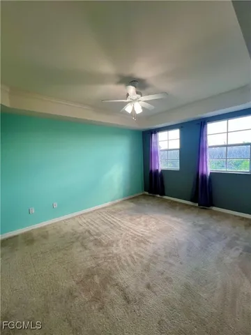 a view of an empty room with windows and fireplace