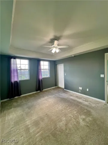a view of an empty room with window and a fireplace