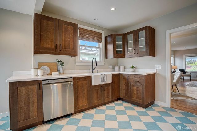 a kitchen with a sink a stove a mirror and cabinets