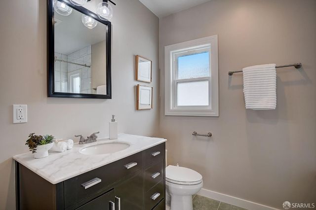 a bathroom with a sink vanity and a toilet