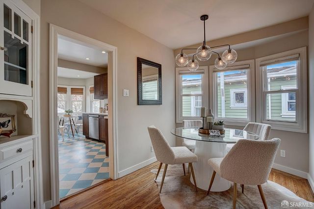 a dining room with wooden floor a chandelier a glass table and chairs