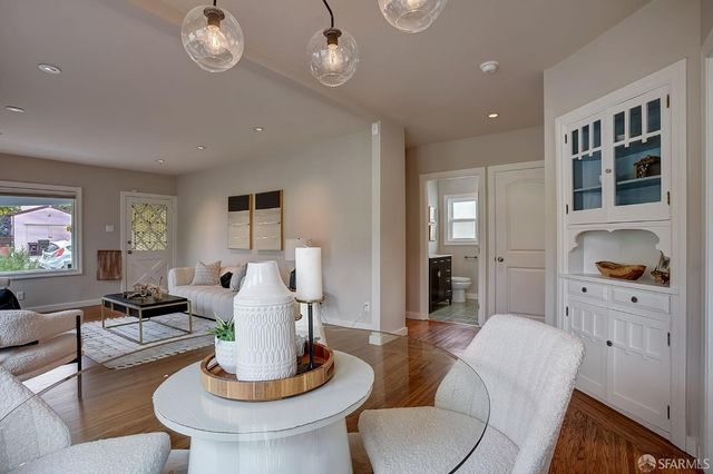 a living room with furniture kitchen view and a window