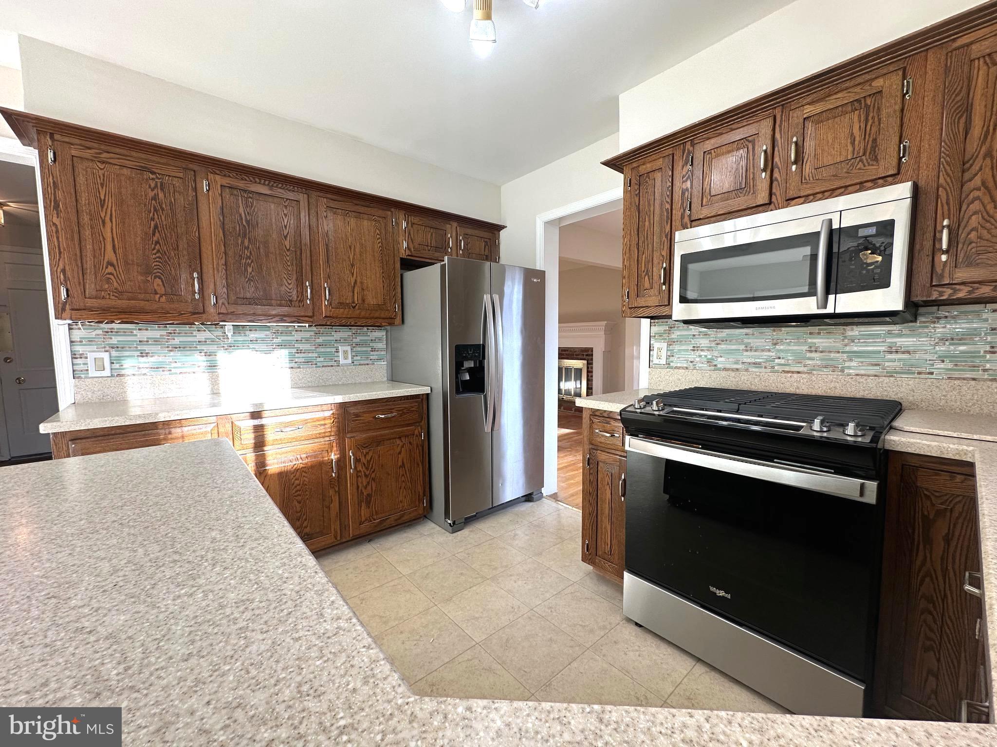 8601 Kenilworth Drive Springfield, VA 22151 - Photo 15 of 47 a kitchen with stainless steel appliances granite countertop a stove microwave and refrigerator