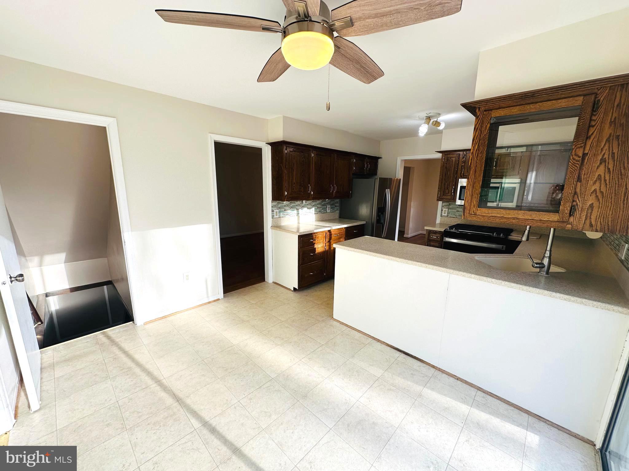 8601 Kenilworth Drive Springfield, VA 22151 - Photo 17 of 47 a kitchen with stainless steel appliances a stove a refrigerator a sink a microwave oven with a dining table and chairs