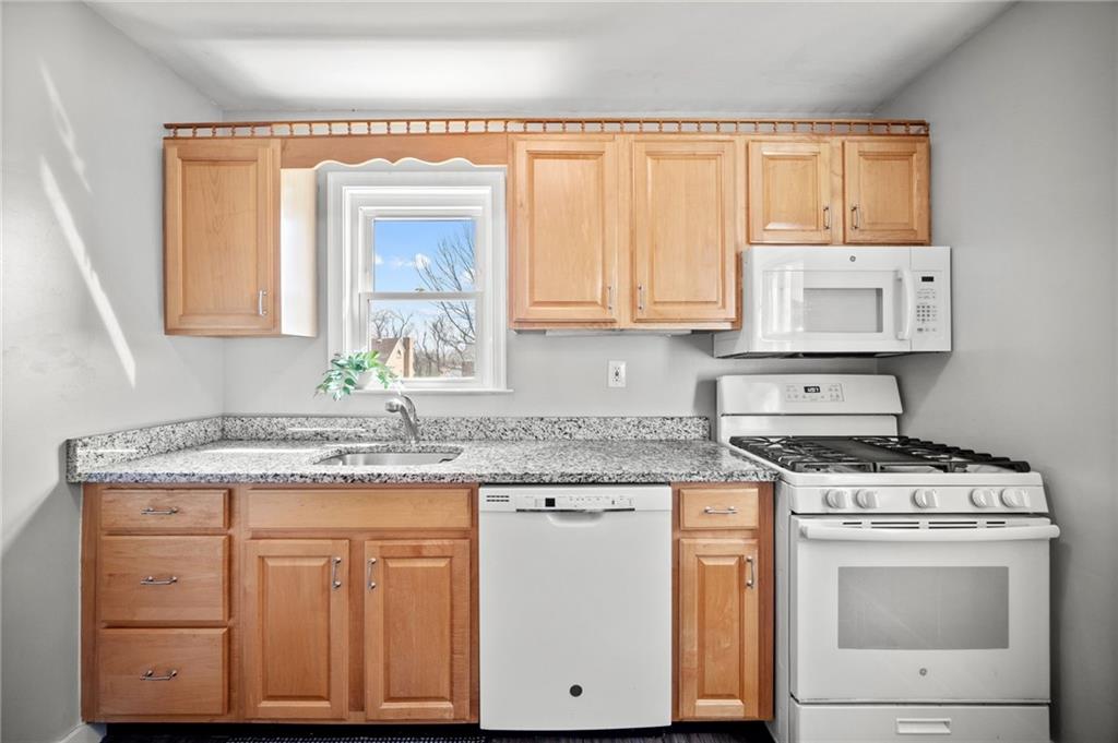 416 Phillips Avenue McKees Rocks, PA 15136 - Photo 14 of 46 a kitchen with granite countertop white cabinets and white appliances