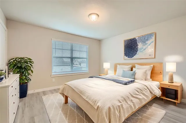 a bedroom with a bed and a potted plant