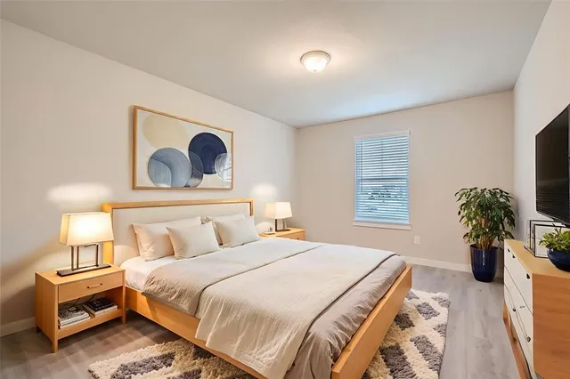 a bedroom with a bed and a potted plant