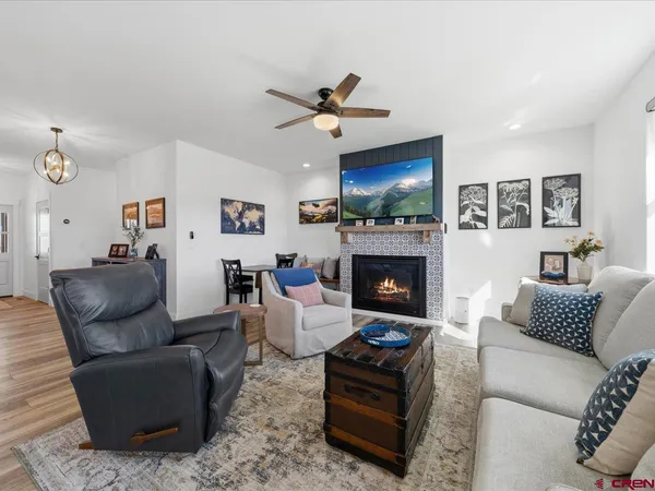 a living room with furniture a flat screen tv and a fireplace