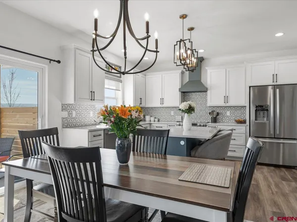 a view of a dining room with furniture a chandelier and wooden floor