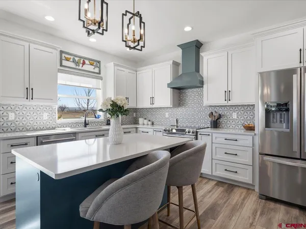 a kitchen with stainless steel appliances a sink stove and refrigerator