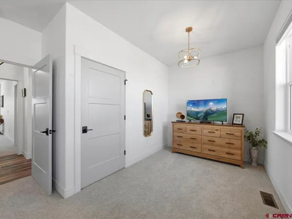 a room with furniture a flat screen tv and a dresser