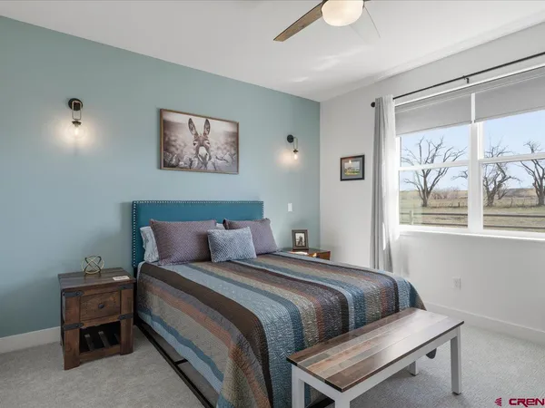 a bedroom with a bed and a painting on the wall