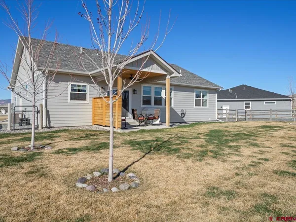 a view of a house with a yard and large tree
