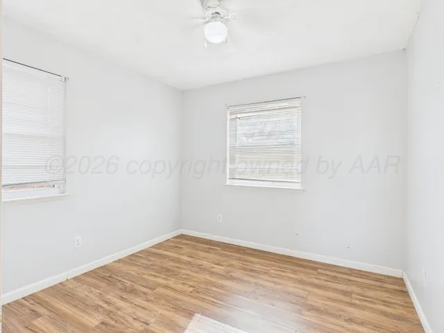 a view of a room with wooden floor and a ceiling fan