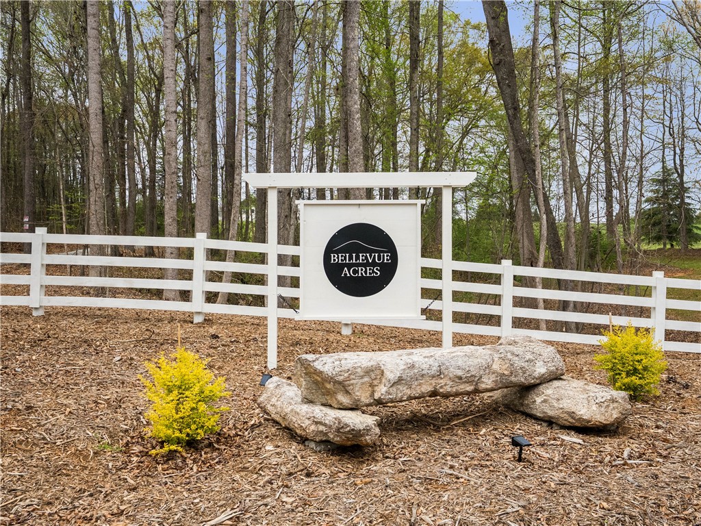331 Bakerville Road Easley, SC 29642 - Photo 42 of 43 The welcoming entrance to Bellevue Acres features a pristine white fence and natural stone landscaping.