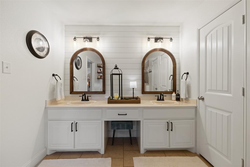 5200 Medallion Court Midlothian, TX 76065 - Photo 20 of 40 Remodeled primary bathroom with shiplap wall, new mirrors and light fixtures.