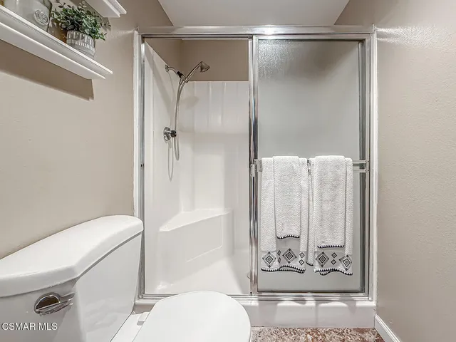 a bathroom with a granite countertop toilet sink and shower