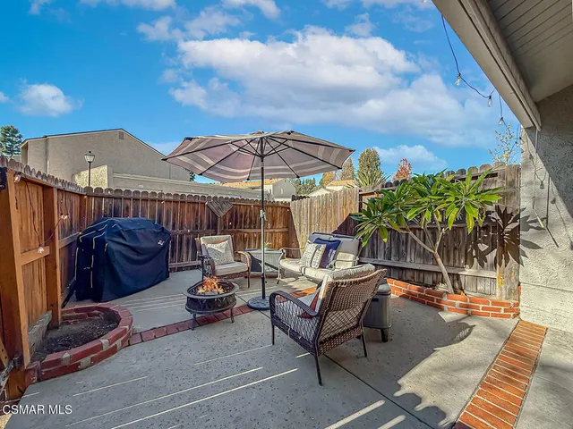 a view of a patio with couches under an umbrella