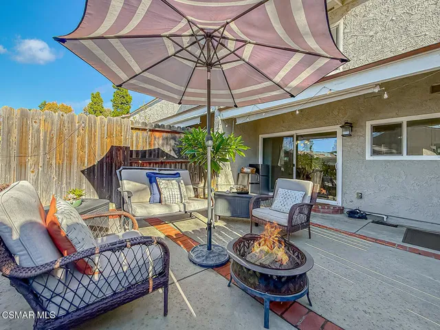 a view of a patio with a dining table and chairs under an umbrella