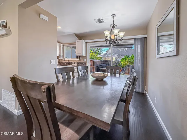 a view of a dining room with furniture a chandelier and wooden floor