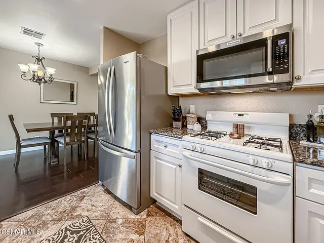 a kitchen with stainless steel appliances white cabinets a stove a microwave and a refrigerator