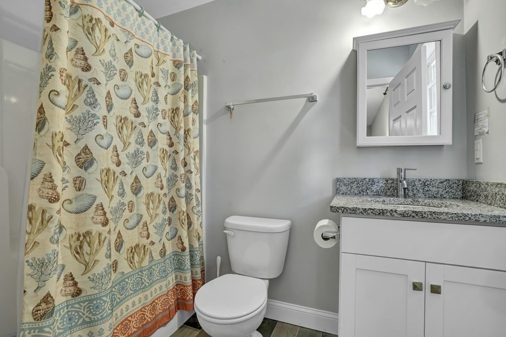 18 Castleton Avenue Randolph, MA 02368 - Photo 12 of 25 a bathroom with a granite countertop toilet a sink and a mirror