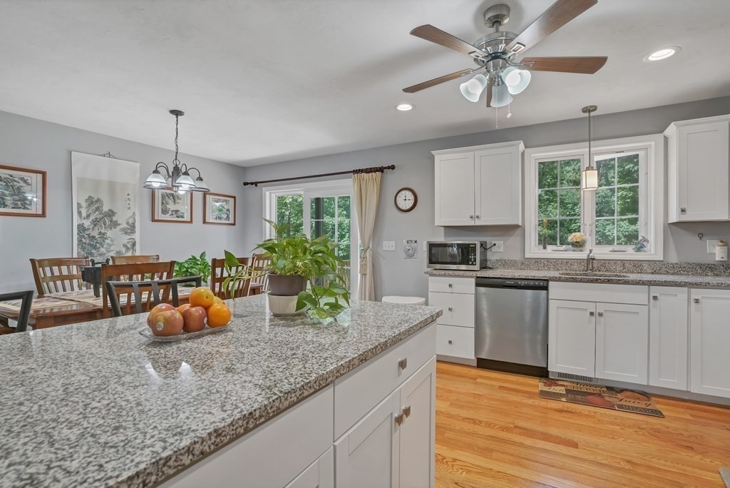 18 Castleton Avenue Randolph, MA 02368 - Photo 5 of 25 a kitchen with granite countertop a stove a sink a dining table and chairs