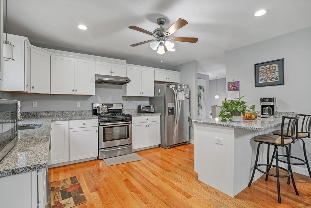 18 Castleton Avenue Randolph, MA 02368 - Photo 6 of 25 a kitchen with stainless steel appliances granite countertop a stove cabinets and a refrigerator
