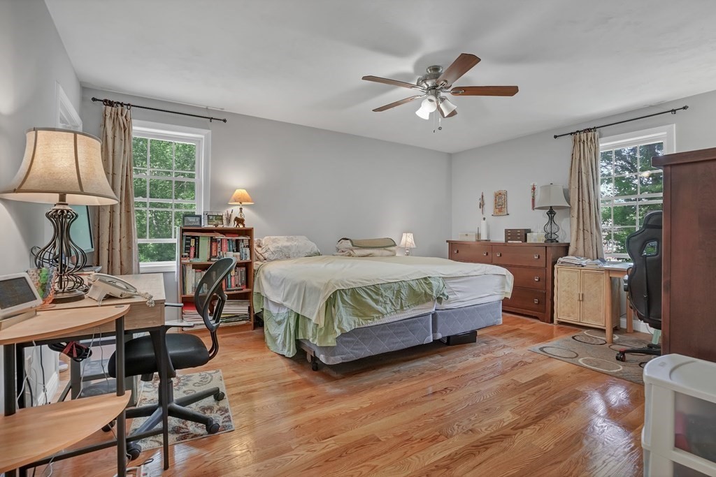 18 Castleton Avenue Randolph, MA 02368 - Photo 10 of 25 a bedroom with a bed a desk and chair with wooden floor