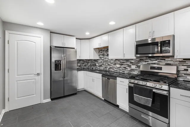 a kitchen with stainless steel appliances a stove microwave and refrigerator