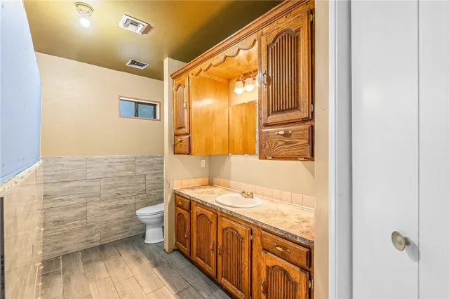 a bathroom with a granite countertop double vanity sink a mirror and a shower