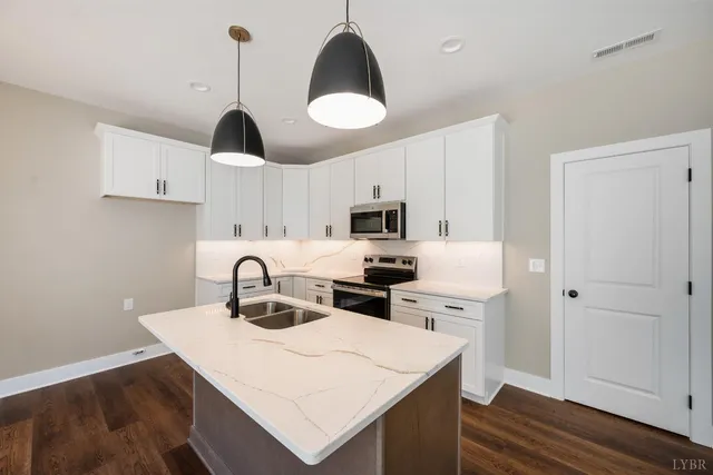 a kitchen with a sink a stove and cabinets