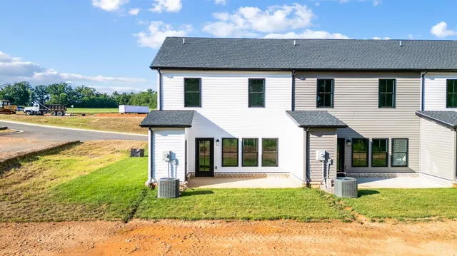 a view of a house with a yard and potted plants