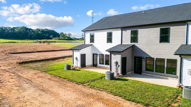 a front view of a house with a yard and potted plants