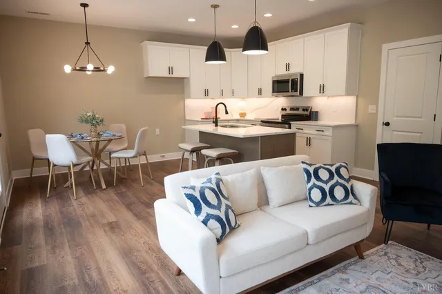 a living room with furniture kitchen and a wooden floor