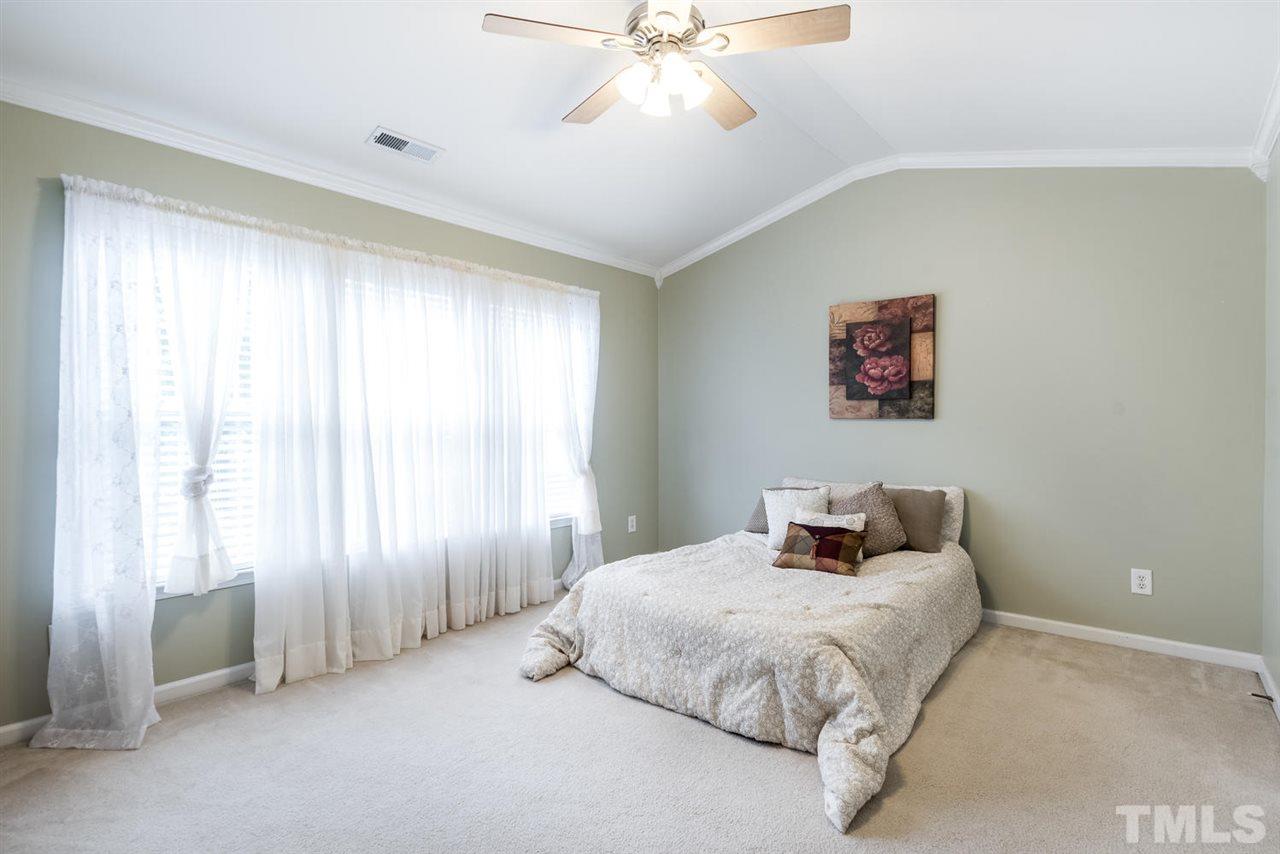 5522 Shady Crest Drive Raleigh, NC 27613 - Photo 18 of 25 a bedroom with a bed and a chandelier