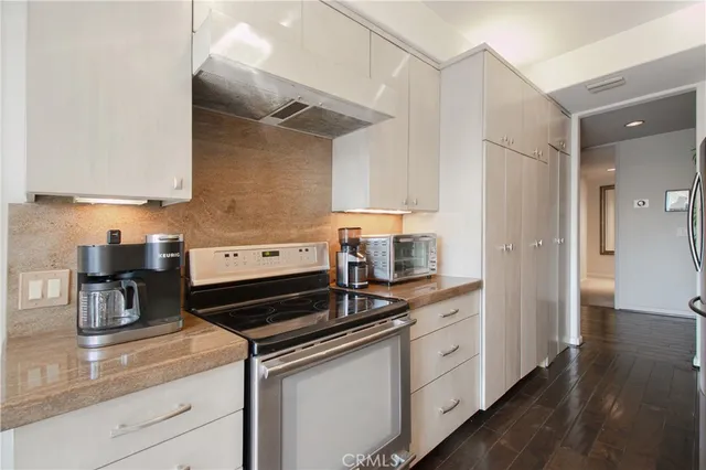 a kitchen with a stove and white cabinets