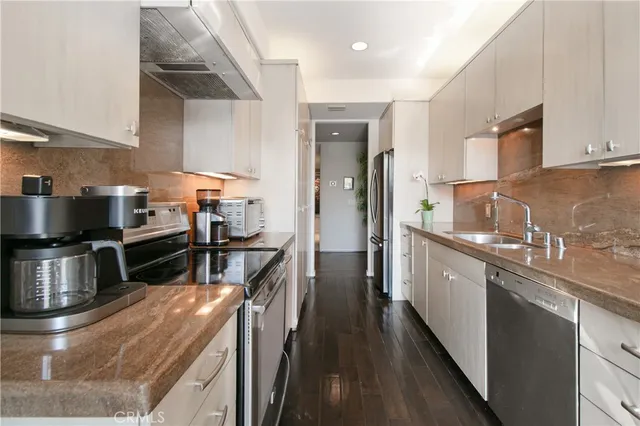 a kitchen with stainless steel appliances granite countertop a stove a sink and a refrigerator