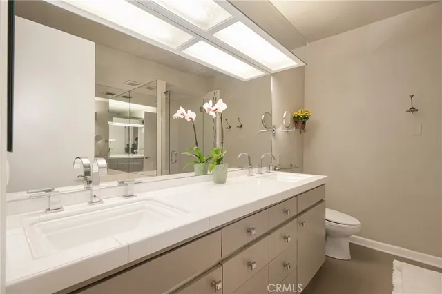 a bathroom with a sink and a mirror with toilet