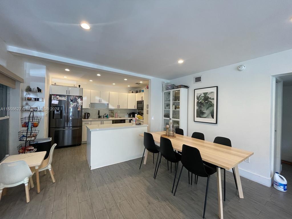 a open kitchen with stainless steel appliances kitchen island a table and chairs in it