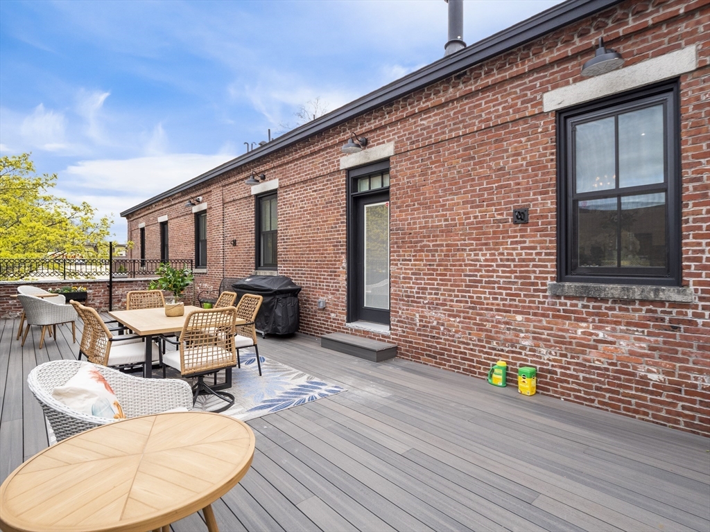 140 Middlesex Street, Unit 3 Lowell, MA 01852 - Photo 27 of 30 a view of a patio with table and chairs and wooden floor