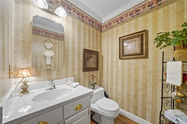 a bathroom with a granite countertop sink mirror vanity and toilet