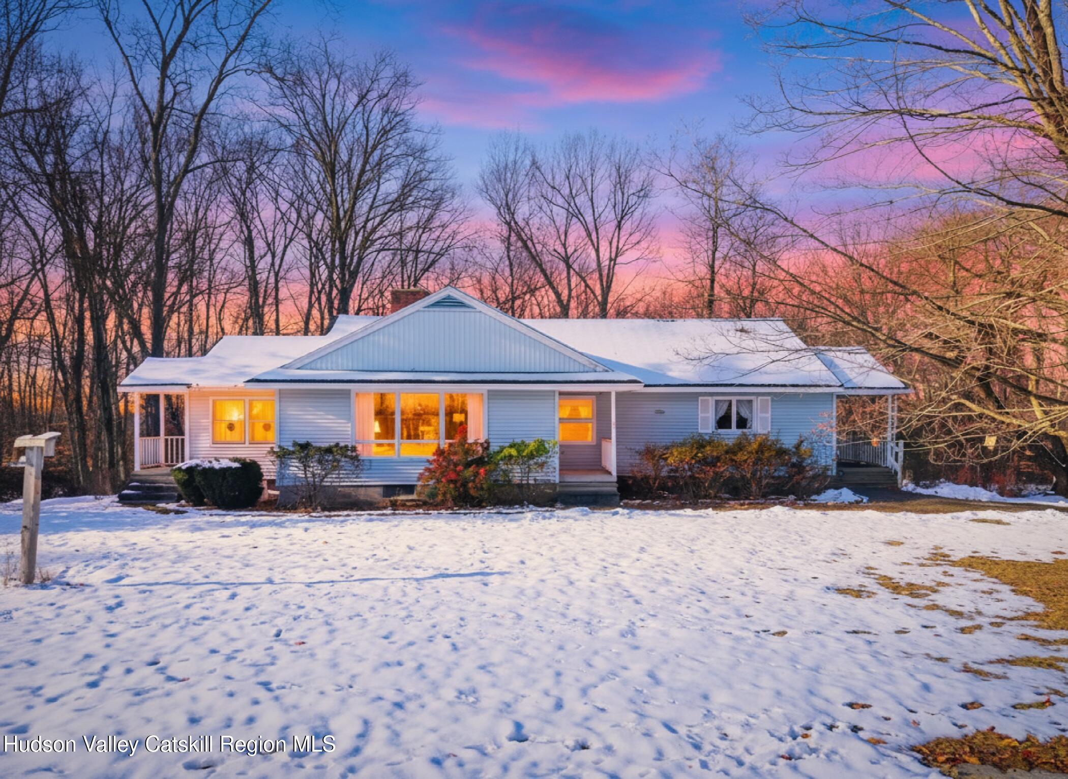 a front view of a house with a yard covered in snow