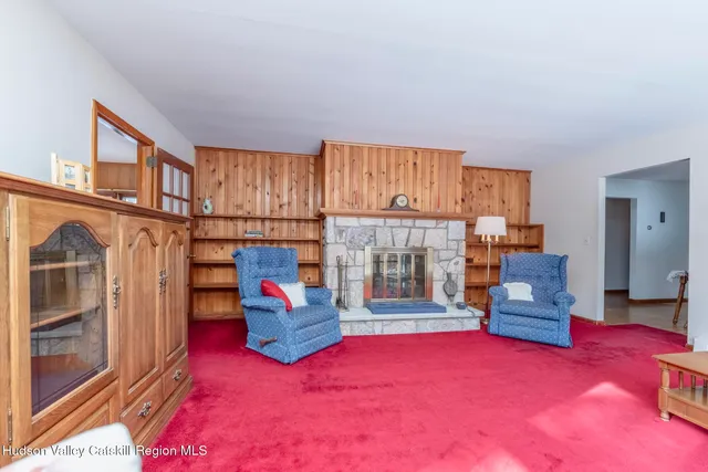 a living room with furniture and a floor to ceiling window next to a ceiling window