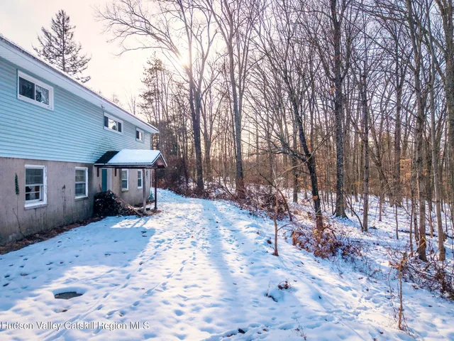 a front view of a house with a yard covered in snow