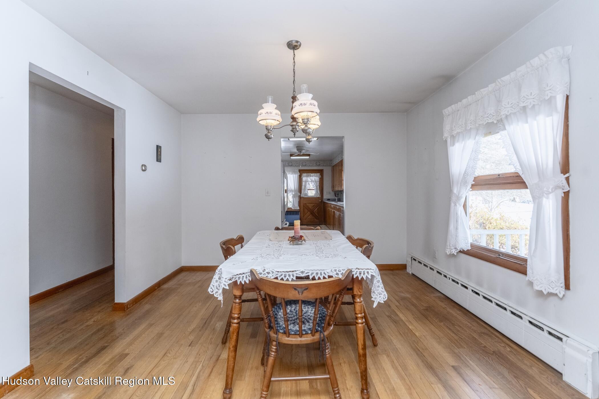 232 Cedar Hill Road High Falls, NY 12440 - Photo 9 of 42 a dining room with wooden floor a chandelier a wooden table and chairs