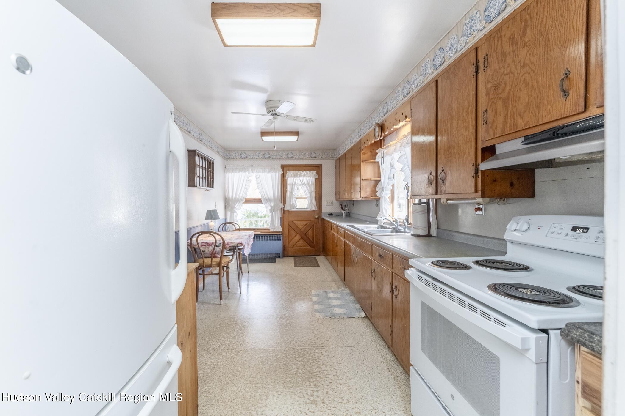 232 Cedar Hill Road High Falls, NY 12440 - Photo 10 of 42 a kitchen with stainless steel appliances granite countertop a stove top oven a sink a dining table and chairs with wooden floor